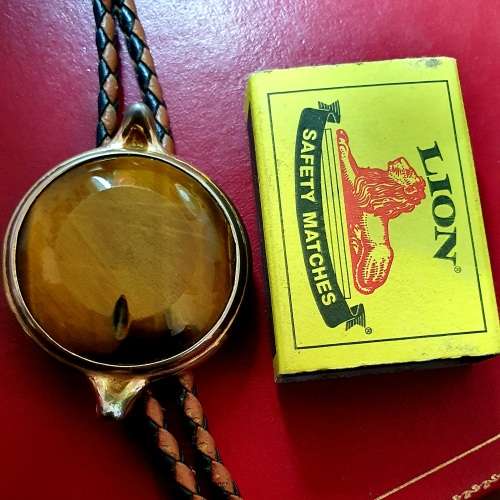 ANTIQUE  TIGER EYE AND BRAIDED LEATHER MENS NECK BOLO TIE WITH BULLET ENDS.