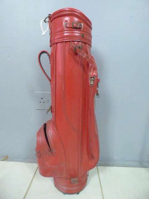 A FANTASTIC RED TONEY PENNA GOLF BAG WITH A TONEY PENNA GOLD 1, TI BUBBLE 2 & 4 PUTTERS.