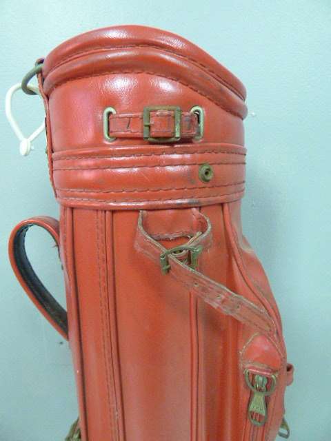 A FANTASTIC RED TONEY PENNA GOLF BAG WITH A TONEY PENNA GOLD 1, TI BUBBLE 2 & 4 PUTTERS.