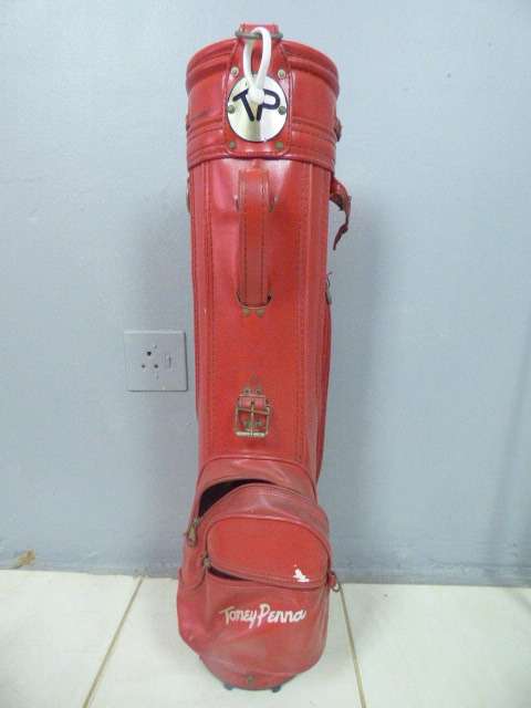 A FANTASTIC RED TONEY PENNA GOLF BAG WITH A TONEY PENNA GOLD 1, TI BUBBLE 2 & 4 PUTTERS.