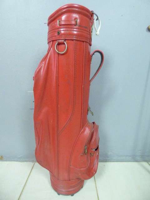 A FANTASTIC RED TONEY PENNA GOLF BAG WITH A TONEY PENNA GOLD 1, TI BUBBLE 2 & 4 PUTTERS.