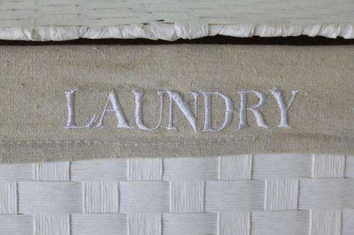 A FABULOUS WHITE LAUNDRY BASKET WITH A NATURAL LINEN (REMOVABLE) EMBROIDERED LINEN BAG