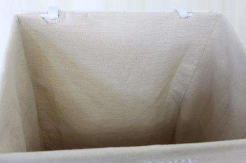 A FABULOUS WHITE LAUNDRY BASKET WITH A NATURAL LINEN (REMOVABLE) EMBROIDERED LINEN BAG