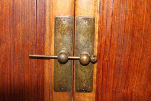 AN INCREDIBLE ANTIQUE DOUBLE DOOR CHINESE CABINET WITH TRADITIONAL HANDLES AND HINGES AND A DRAWER