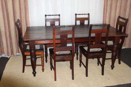 A SPECTACULAR SOLID STINKWOOD 6 TO 8-SEATER DINING TABLE WITH SOLID TURNED LEGS IN AWESOME CONDITION