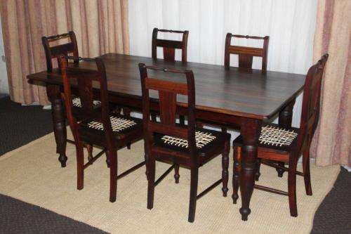 A SPECTACULAR SOLID STINKWOOD 6 TO 8-SEATER DINING TABLE WITH SOLID TURNED LEGS IN AWESOME CONDITION