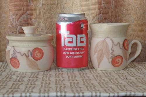 A FABULOUS STONEWARE MILK JUG AND LIDDED SUGAR BOWL SET WITH STUNNING HAND PAINTED DETAILING