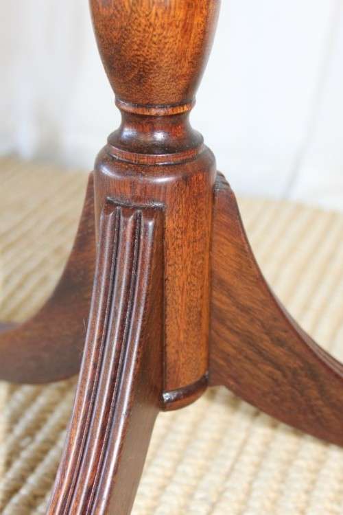 A MAGNIFICENT TEAK OCCASIONAL TABLE WITH BROAD RIMMED DETAILED TOP AND THREE BRASS TOE CAPS