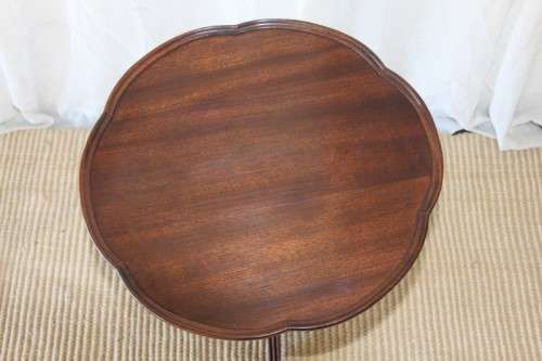 A MAGNIFICENT TEAK OCCASIONAL TABLE WITH BROAD RIMMED DETAILED TOP AND THREE BRASS TOE CAPS