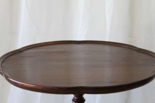 A MAGNIFICENT TEAK OCCASIONAL TABLE WITH BROAD RIMMED DETAILED TOP AND THREE BRASS TOE CAPS