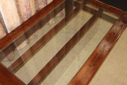 An exquisitely made solid wooden centre coffee/ occasional table with a toughened glass top RS17