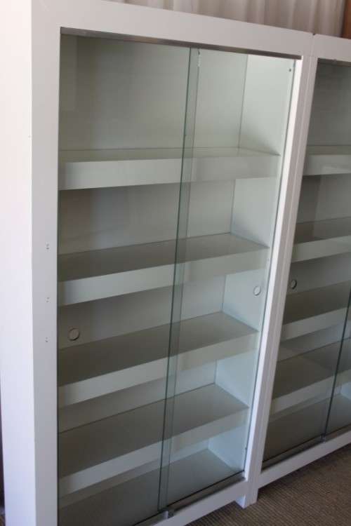 AN AWESOME 1.6m TALL WHITE DOUBLE DIVISION BOOK CASE WITH GLASS SLIDING DOORS & AMPLE PACKING SPACE