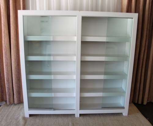 AN AWESOME 1.6m TALL WHITE DOUBLE DIVISION BOOK CASE WITH GLASS SLIDING DOORS & AMPLE PACKING SPACE