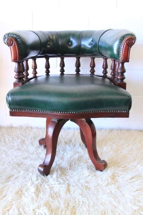 A spectacular solid mahogany "captain's swivel chair" with period British green upholstery