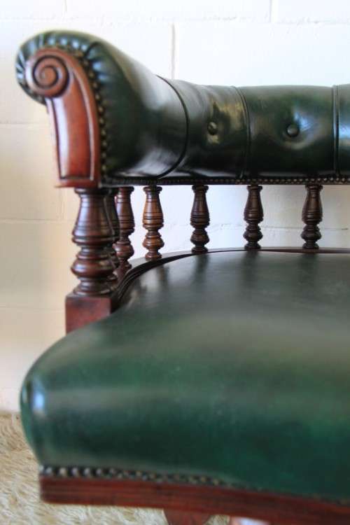 A spectacular solid mahogany "captain's swivel chair" with period British green upholstery