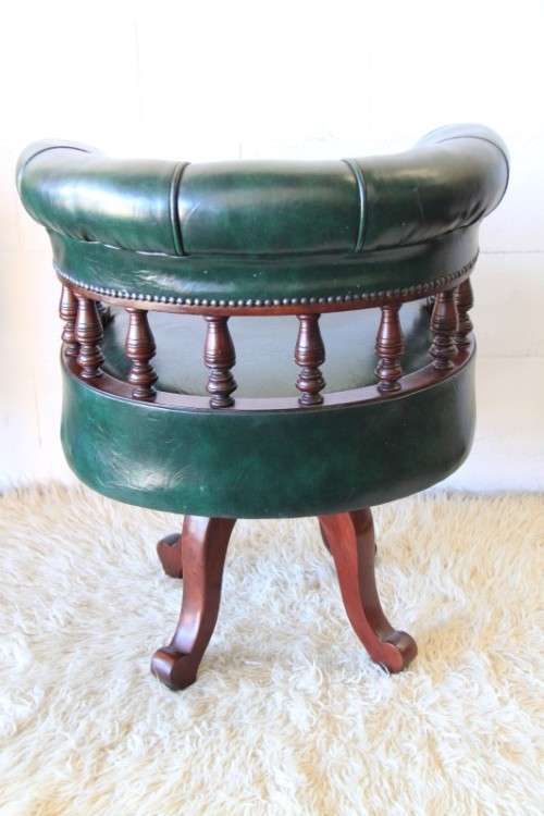 A spectacular solid mahogany "captain's swivel chair" with period British green upholstery