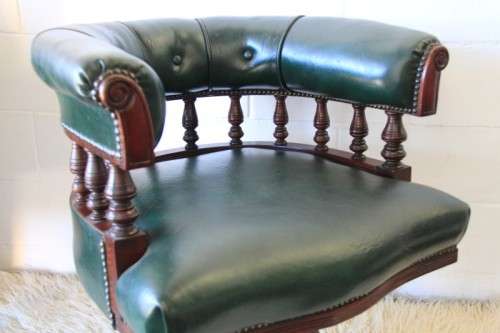 A spectacular solid mahogany "captain's swivel chair" with period British green upholstery