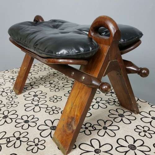 A wonderful vintage Moroccan "Camel Saddle" ottoman stool with stunning brass inlay detailing