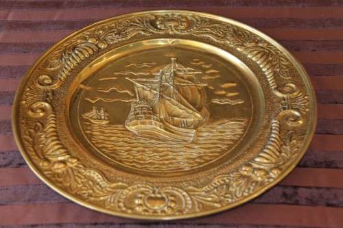 A lovely vintage brass wall plate with a hand-embossed "ship" detailing and a wall hook on the back