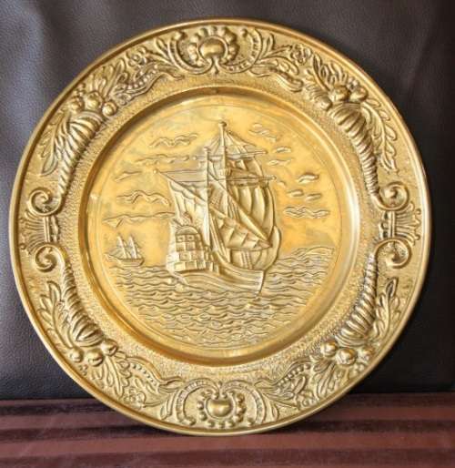 A lovely vintage brass wall plate with a hand-embossed "ship" detailing and a wall hook on the back