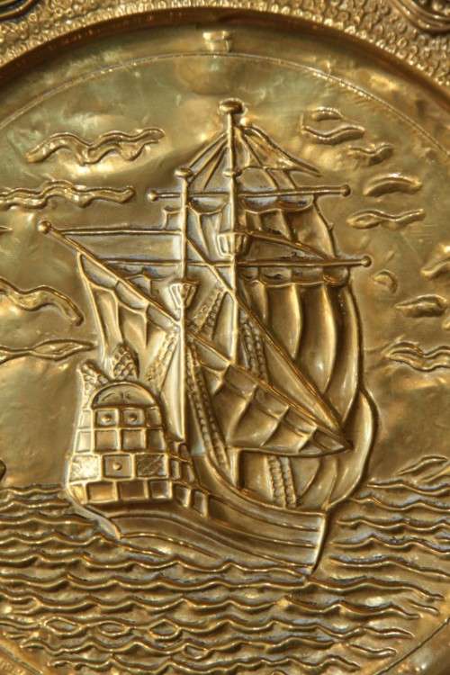 A lovely vintage brass wall plate with a hand-embossed "ship" detailing and a wall hook on the back