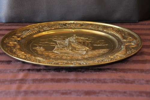 A lovely vintage brass wall plate with a hand-embossed "ship" detailing and a wall hook on the back