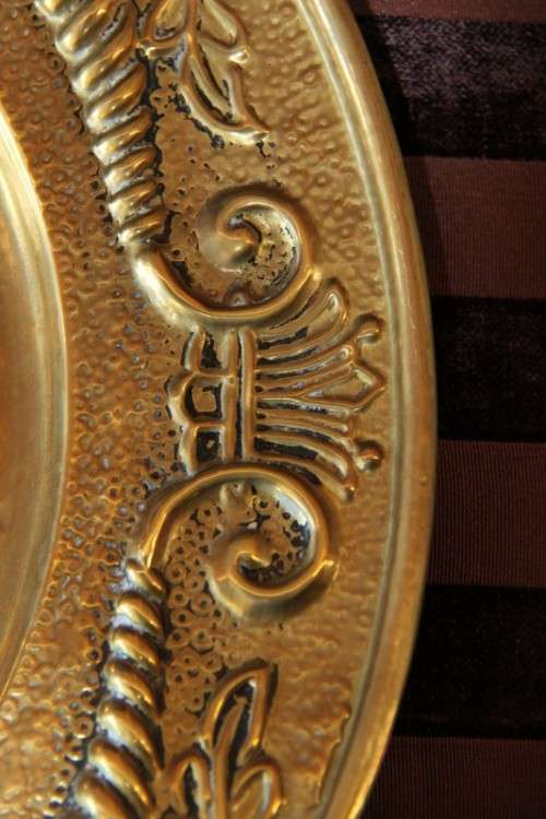 A lovely vintage brass wall plate with a hand-embossed "ship" detailing and a wall hook on the back