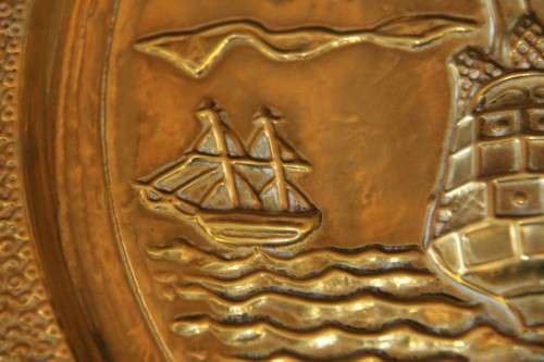 A lovely vintage brass wall plate with a hand-embossed "ship" detailing and a wall hook on the back