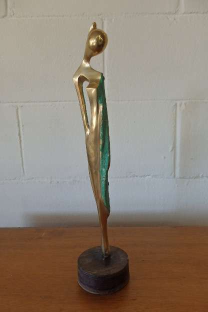 A wonderful tall solid brass abstract figurine mounted on a wooden base in great condition