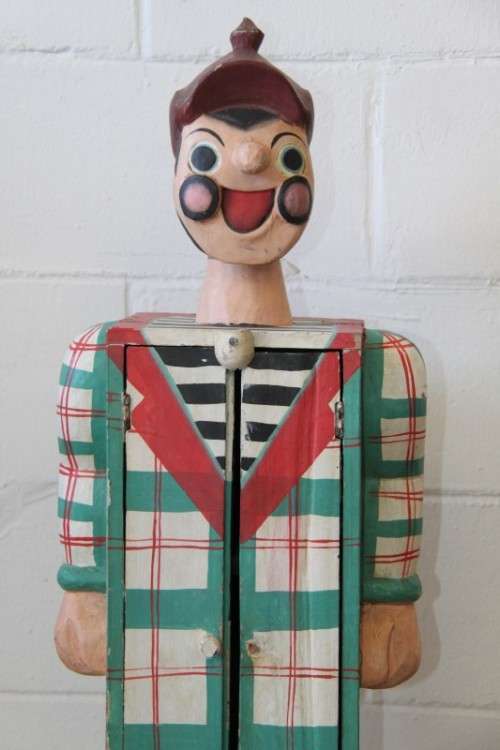 An interesting and unusual free standing antique tabletop cabinet in the form of a clown w/ shelves