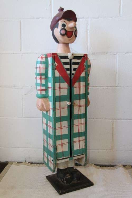 An interesting and unusual free standing antique tabletop cabinet in the form of a clown w/ shelves