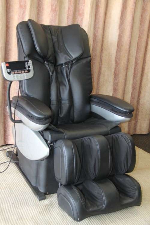 An incredible large automatic massage chair with electronic keypad and headphones