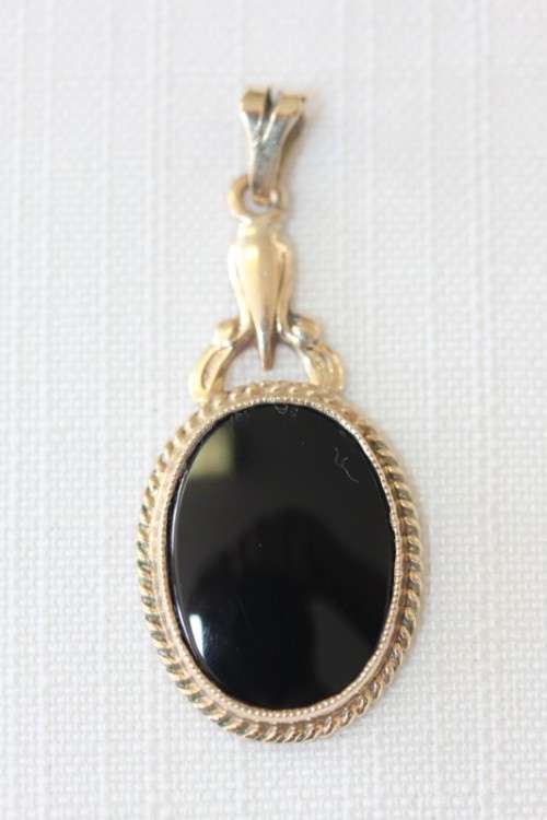 A magnificent 9ct gold pendant with large Onyx stone and amazing braiding around the edges