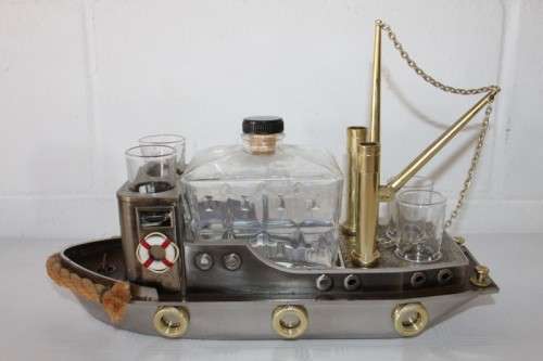 An amazing vintage tugboat decanter with a wind-up music box and four shot glasses