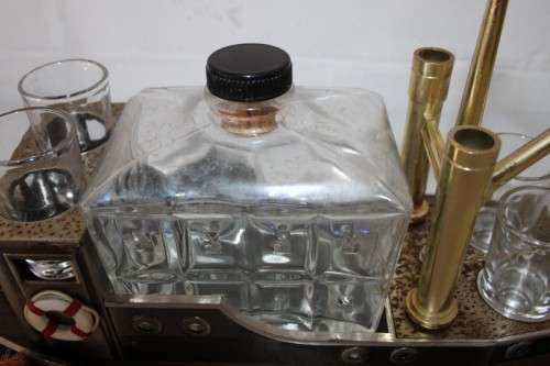 An amazing vintage tugboat decanter with a wind-up music box and four shot glasses