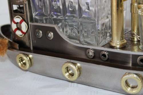 An amazing vintage tugboat decanter with a wind-up music box and four shot glasses