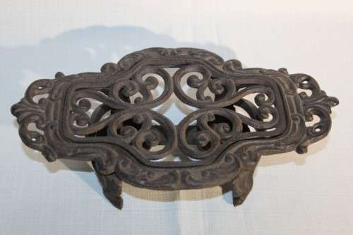 A cast iron pot warmer with space for two tealight candles, something special for dinner parties
