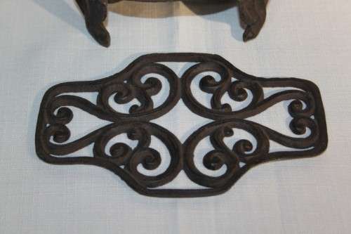 A cast iron pot warmer with space for two tealight candles, something special for dinner parties