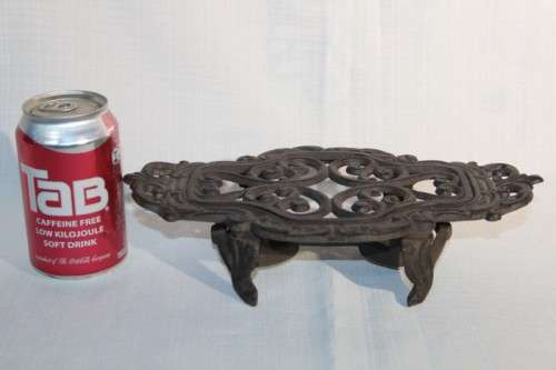 A cast iron pot warmer with space for two tealight candles, something special for dinner parties