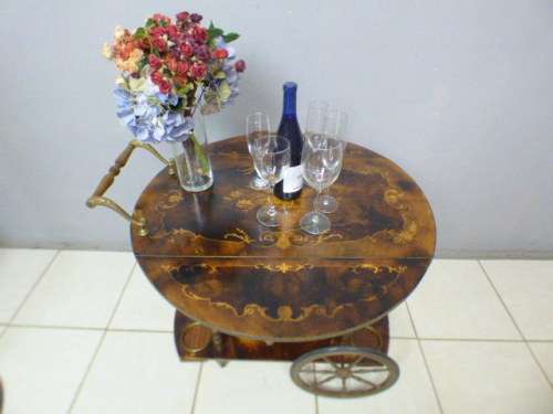 An exquisite Italian Sorrento style wood antique drinks trolley on original castors and wheels.