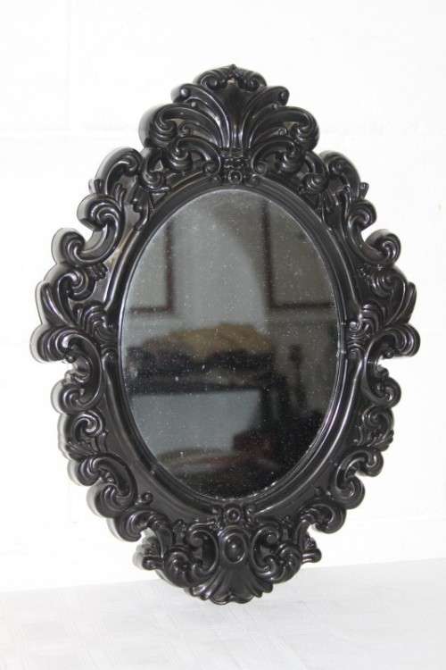An amazing black ornately moulded oval wall mirror in great condition. RS17M