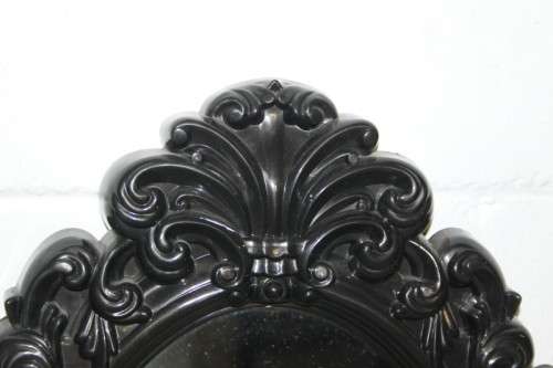 An amazing black ornately moulded oval wall mirror in great condition. RS17M