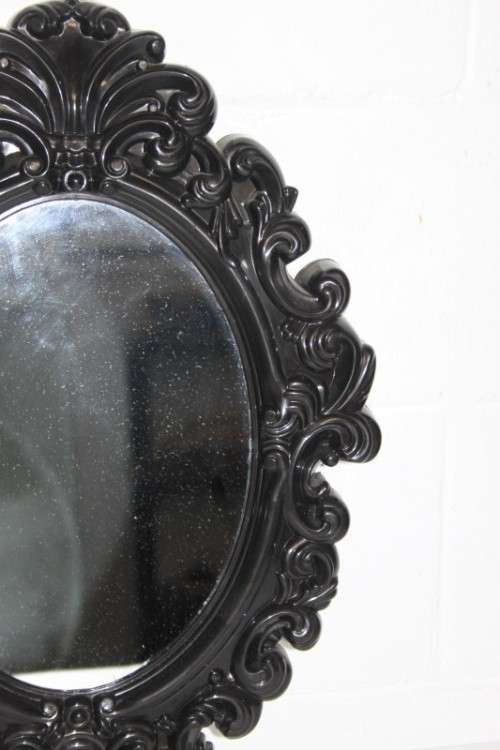 An amazing black ornately moulded oval wall mirror in great condition. RS17M