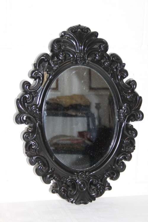 An amazing black ornately moulded oval wall mirror in great condition. RS17M