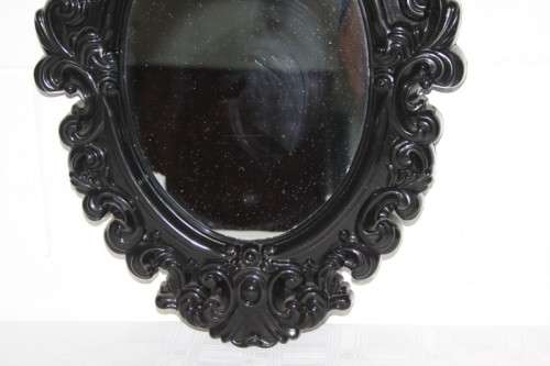 An amazing black ornately moulded oval wall mirror in great condition. RS17M