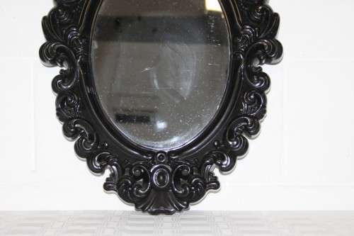An amazing black ornately moulded oval wall mirror in great condition. RS17M