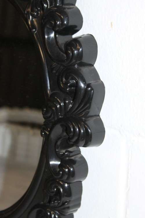 An amazing black ornately moulded oval wall mirror in great condition. RS17M