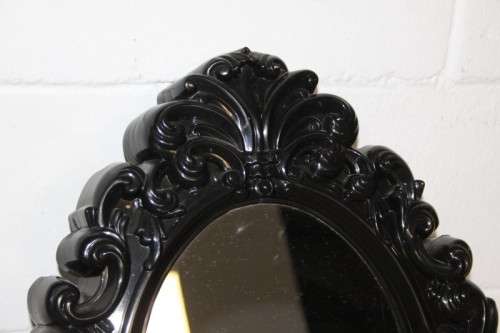 An amazing black ornately moulded oval wall mirror in great condition. RS17M