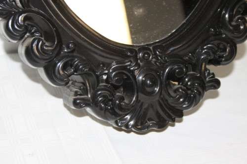 An amazing black ornately moulded oval wall mirror in great condition. RS17M