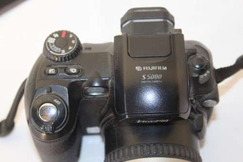 A Fujifilm FinePix S5000 Zoom with a strap in a high quality Lowepro bag